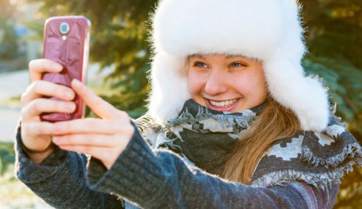 Ragazza usa il cellulare in inverno